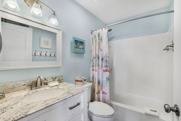 Une salle de bain avec un lavabo, des toilettes et une douche.