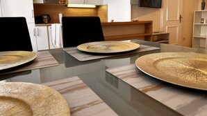 A modern kitchen with white cabinets, a microwave, and a flat-screen TV mounted on the wall.
