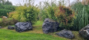 A garden with large rocks and various plants. - - Le Torii - Hélène and Will's Vacation Homes (Maurepas)