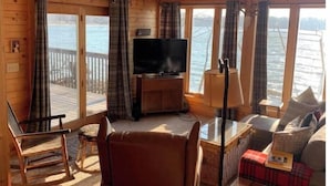 A cozy cabin with a TV, seating, and a view of the water. - German lake Family Adventures

 (Waterville)