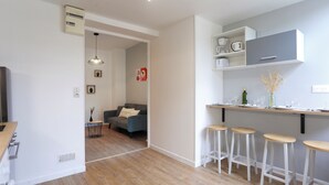 Una cocina moderna con armarios blancos, una encimera y taburetes de bar.