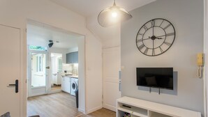 Una sala de estar moderna con un reloj de pared grande, un televisor de pantalla plana y un diseño minimalista.