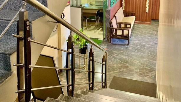 Una escalera conduce a una habitación con un escritorio, una silla y una pared de madera con un cartel.