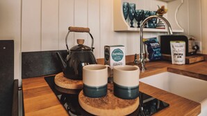 A kitchen counter with a kettle, two mugs, and a box of FURNISS fairings.