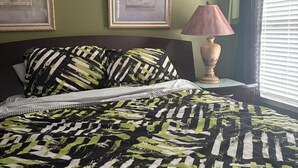 A bedroom with a bed, two framed pictures on the wall, a lamp, and a window with curtains. - 4-bedroom house in charming Union City near airport  (Union City)