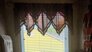 A bathroom with a large bathtub, a window with a decorative curtain, and a towel rack. - 4-bedroom house in charming Union City near airport  (Union City)
