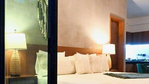 A hotel room with a bed, two bedside lamps, an air conditioning unit, and a view of the outside. - Sunset Kin Beach Apartments (Playa del Carmen)