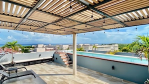 A rooftop terrace with wooden pergola, outdoor seating, and a swimming pool. - Sunset Kin Beach Apartments (Playa del Carmen)