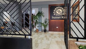 A hotel entrance with a modern design, featuring a geometric metal gate, a wooden door with a sign, and potted plants. - Sunset Kin Beach Apartments (Playa del Carmen)