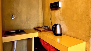 A small kitchenette with a yellow countertop, a kettle, a coffee maker, and a wall-mounted electrical outlet. - La Pahi Palace (Madhubani)