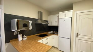 A compact kitchen with a microwave, stove, and refrigerator. - Las Canteras Beach (Las Palmas de Gran Canaria)