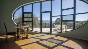 Une pièce dotée d’une grande fenêtre ovale donnant sur un patio aménagé avec du mobilier d’extérieur.