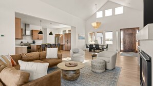 A spacious living area with a modern kitchen, dining space, and a fireplace.