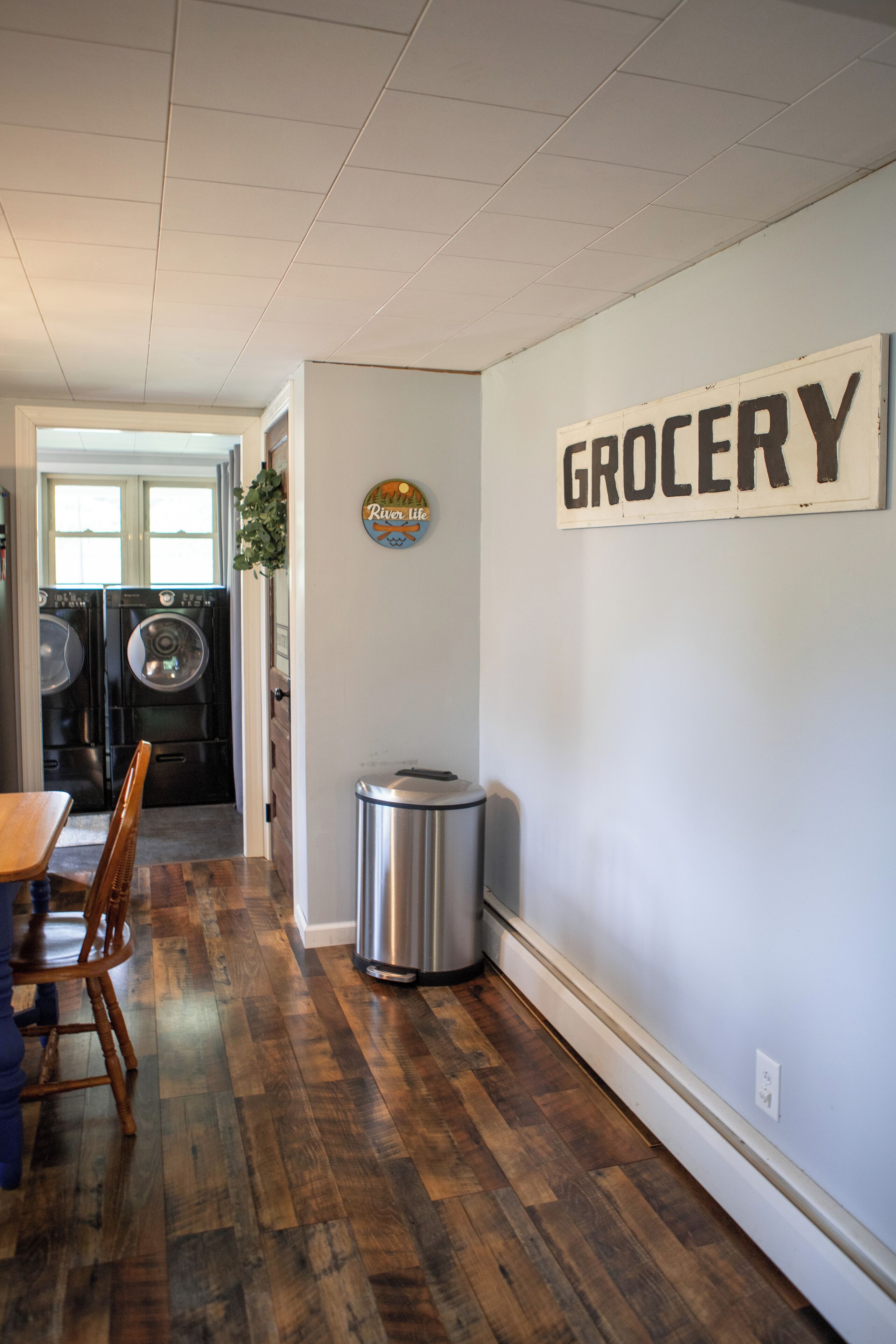 Un cuarto de lavandería con un letrero que dice "GROCERY" en la pared.