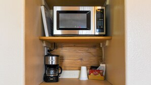 A compact kitchenette with a microwave, coffee maker, and a box of Orville Redenbacher's popcorn. - Dew Duck Inn (Plains)