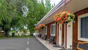 A row of benches outside a building with hanging flower baskets. - Dew Duck Inn (Plains)