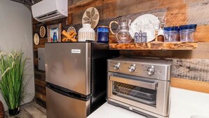 A kitchen with a stainless steel refrigerator, an oven, and a wooden backsplash.