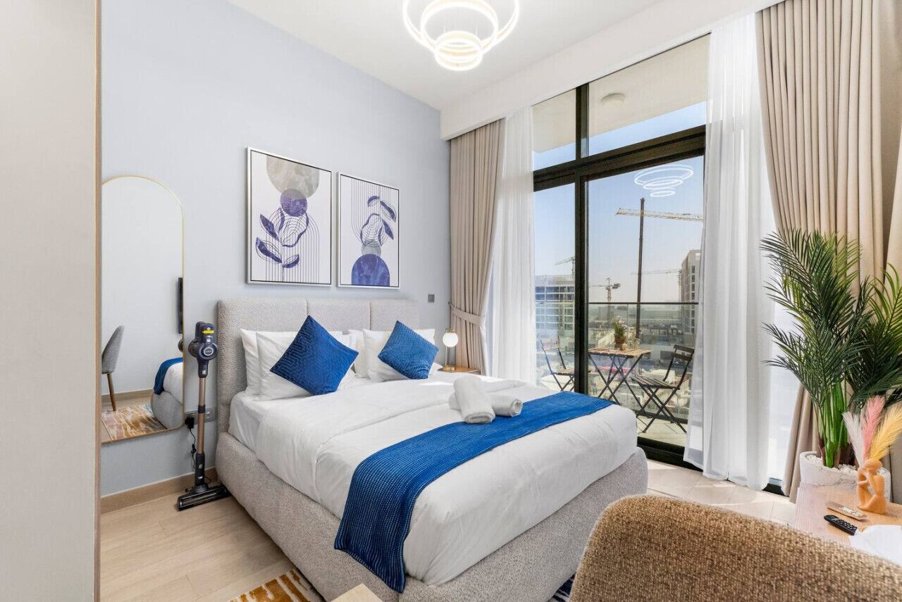 Quarto de hotel moderno com uma cama grande, uma varanda com vista e obras de arte na parede.