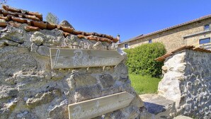 Eine rustikale Steinmauer mit Holzschildern, auf denen 'Le Réveur' und 'Randonnée' stehen.