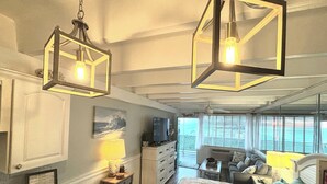 A bedroom with a bed, a dresser, a TV, and a window with blinds. - COUPLES GETAWAY,HONEYMOON SWEET,Beach Front Condo,kitchen,pool,FREE Prkng,GREAT! (Panama City Beach)