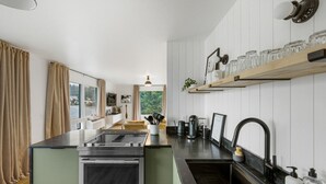 A modern kitchen with a central island, built-in oven, and stainless steel appliances. - Luxury Harbor Escape | Walk to Food & Fun (Juneau)