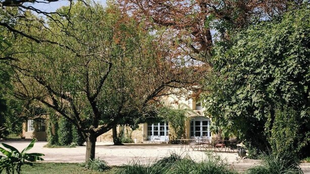 Une cour intérieure avec un bâtiment doté de fenêtres en arc de cercle et d’un espace de repos abrité.