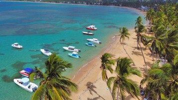 Di pantai, pasir putih, kursi berjemur, dan 3 bar pantai
