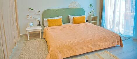 A bedroom with a bed, nightstands, a rug, and decorative wall patterns.