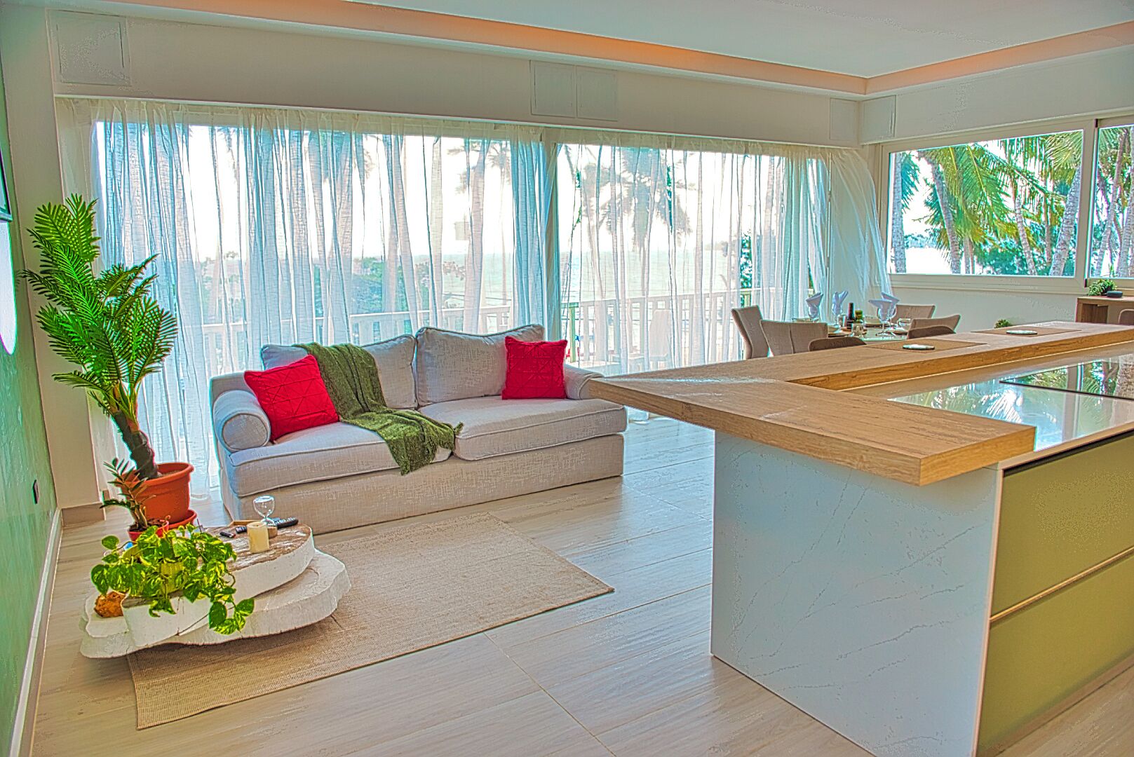 A modern living room with a sofa, a coffee table, and a large window with curtains.