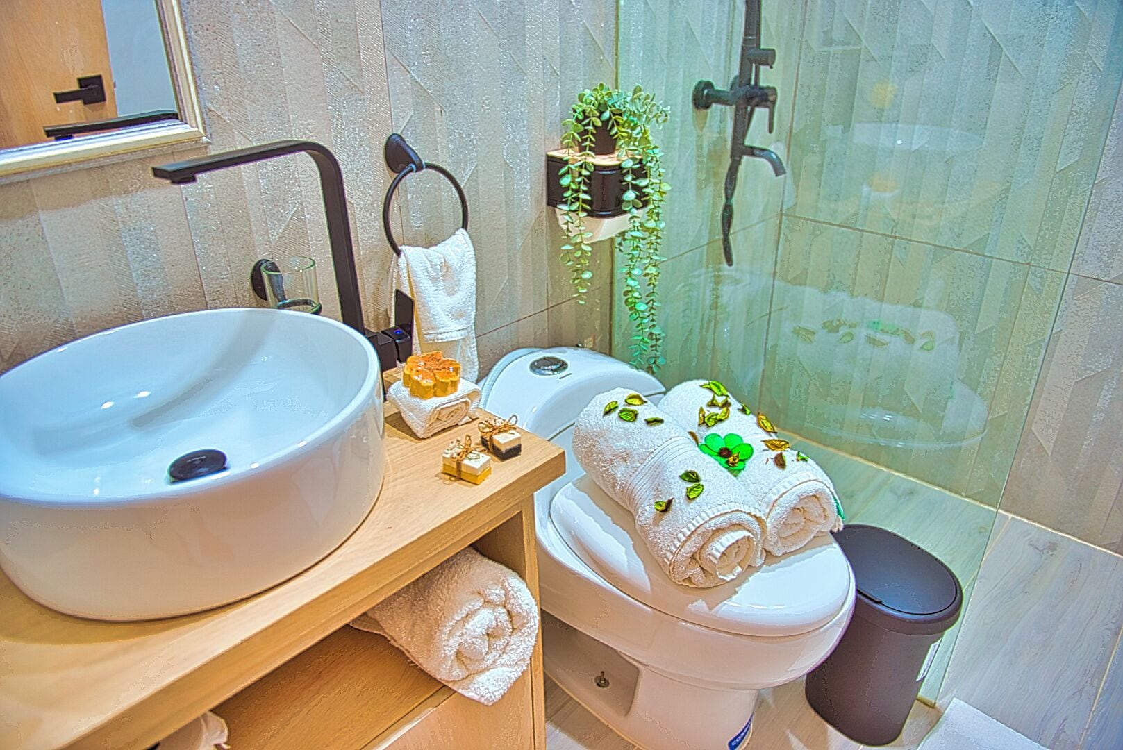 A bathroom with a large white sink, a toilet, and a shower area.