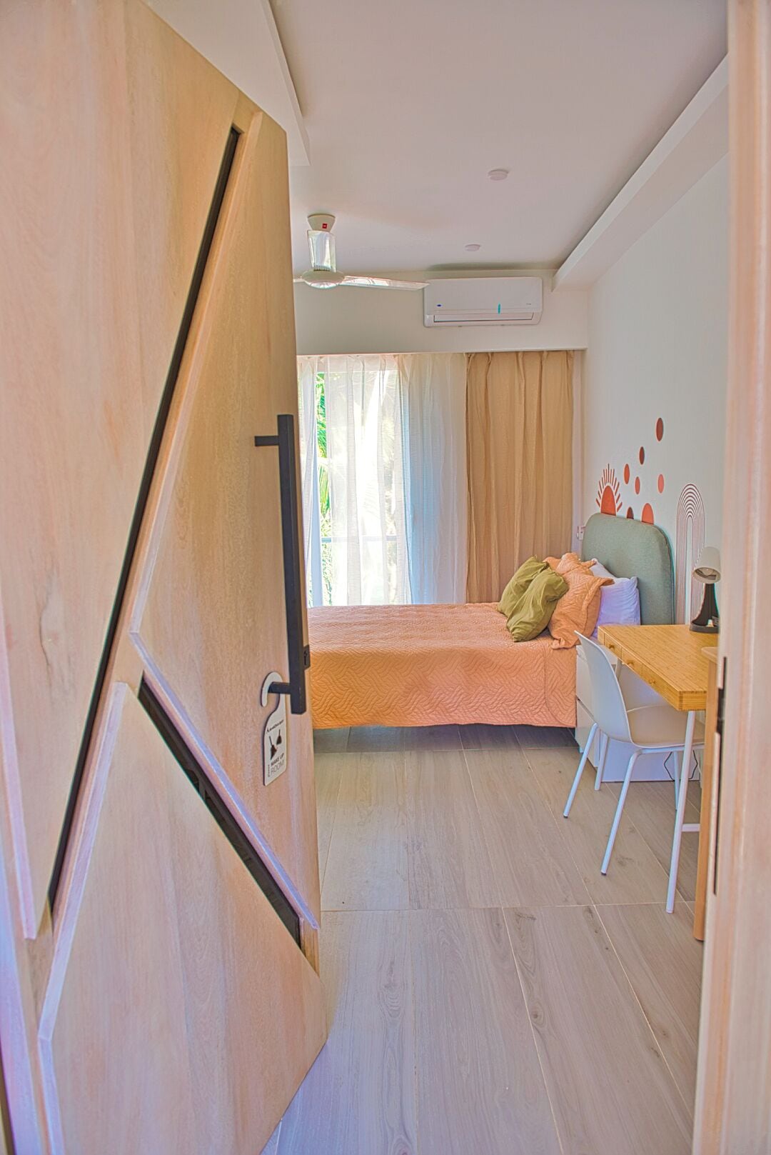 A compact room with a bed, a desk, and a chair.