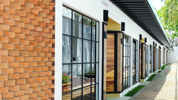 A building with a brick facade and large windows. - Hotel Casa María  (Oaxaca)