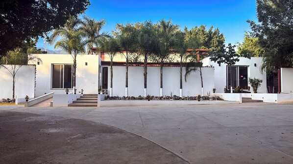 A modern building with a white facade, a central staircase, and a flat roof.