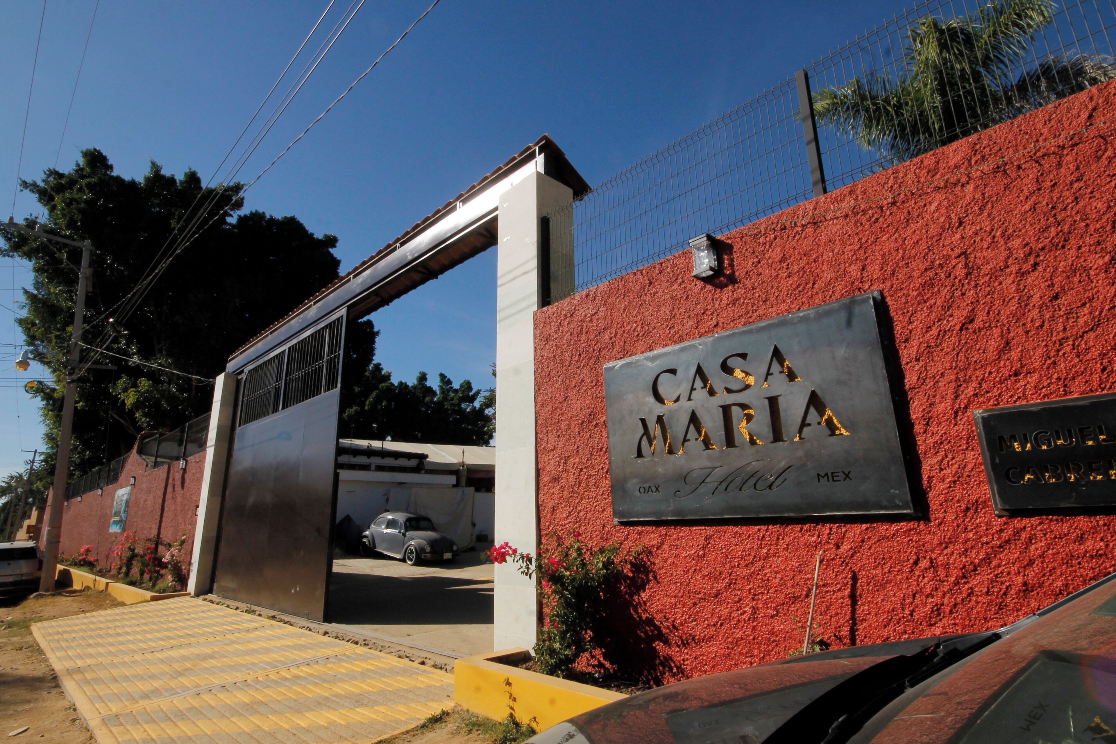 Ein Hotel Eingang mit einer roten Wand und einem Schild, das "CASA MARIA Hotel, Mexico" sagt.