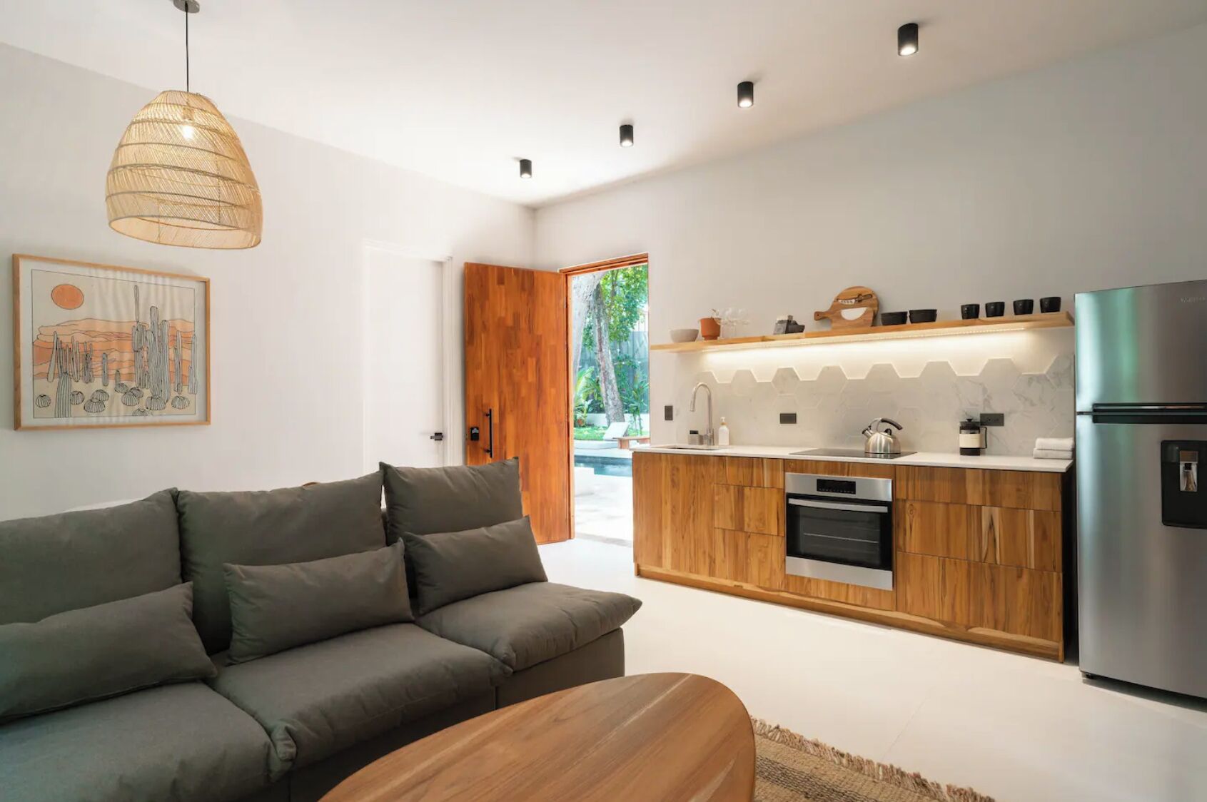 A modern kitchen with wooden cabinets, a built-in oven, and a stainless steel refrigerator.