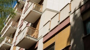 A multi-story building with balconies, a clear blue sky, and some palm trees. - Charming Apartment with AC, WiFi close to St. Peter’s Square, Roma. (Roma)