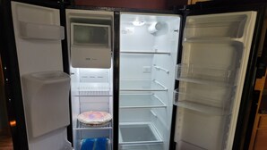 An open refrigerator with multiple shelves and a freezer compartment.