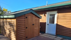 A log cabin with a wooden door and a small porch area.