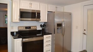 Una cocina moderna con armarios blancos, electrodomésticos de acero inoxidable y un horno empotrado.
