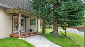 A house with a covered porch, a front door, and a small outdoor grill. - Charming 3-bedroom cottage in serene Enumclaw with AC (Enumclaw)
