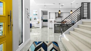 Un interior moderno con escalera, cocina y sala de estar.