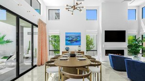 Un comedor moderno con una mesa redonda grande, sillas y una chimenea.