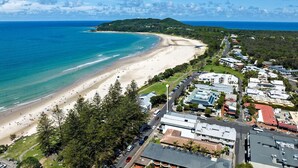 A coastal area with a beach, buildings, and a road. - Luxury On The Bay 2 - Ocean Views (Byron Bay)