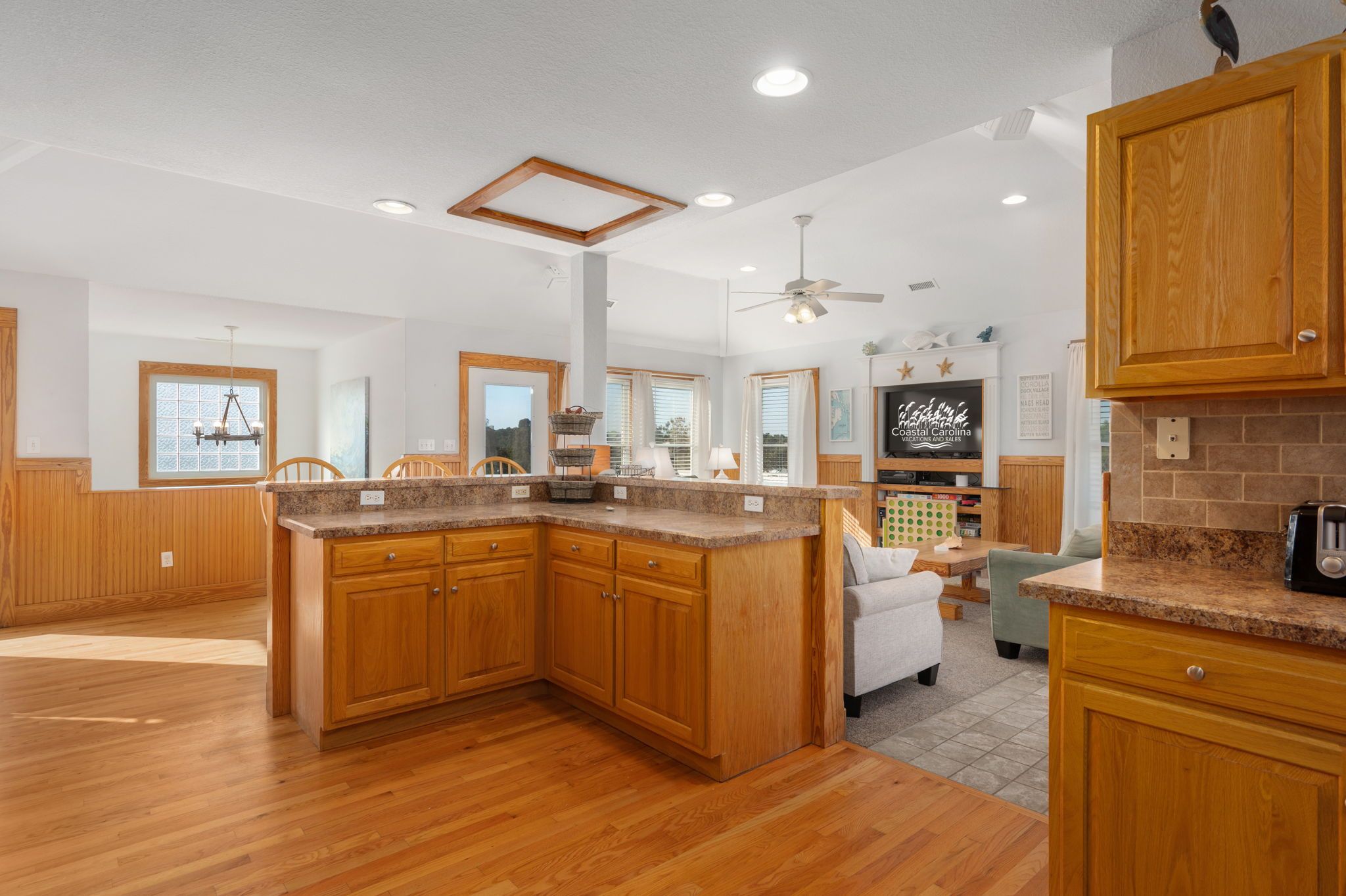 A spacious kitchen with wooden cabinets, a granite countertop, and a built-in island.