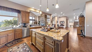 A spacious kitchen with wooden cabinets, a granite countertop, and a large island. - Charming 4-bedroom chalet with AC and WiFi in gorgeous Lake Arrowhead (Lake Arrowhead)