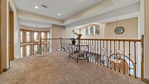 A spacious upper floor with a high ceiling, large windows, and a decorative railing. - Charming 4-bedroom chalet with AC and WiFi in gorgeous Lake Arrowhead (Lake Arrowhead)