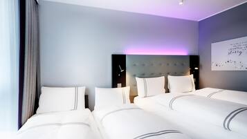 A hotel room with a large bed, a headboard, and a wall with a decorative sign.