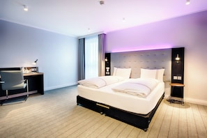 Relax in a serene space with a tufted headboard bed, desk, and comfortable seating area.