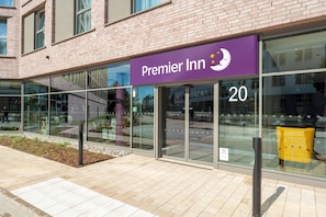 A Premier Inn hotel with a purple sign, large windows, and a brick facade. - Premier Inn Lübeck City Centre (Lubeck)