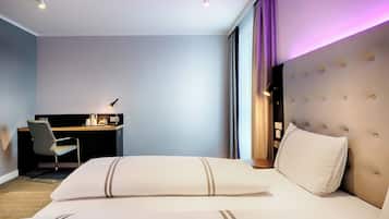 A hotel room with a bed, a desk, and a chair.